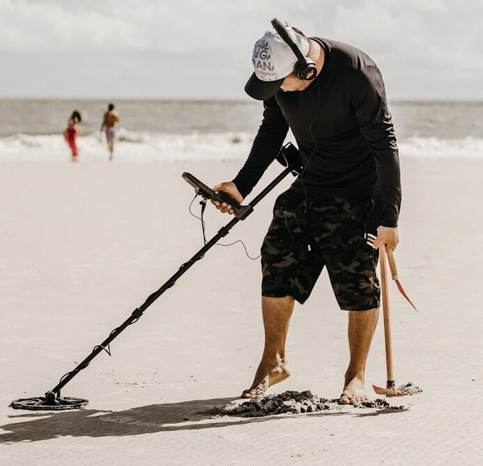 a man holding a stick on the beach